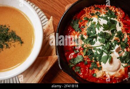 Gros plan vue sur la soupe de citrouilles et les œufs brouillés à la shakshouka avec cachemire servis sur la poêle du Moyen-Orient petit-déjeuner. Gros plan vue de dessus de la soupe de citrouille et des oeufs brouillés de shakshouka sur la poêle moyen-orientale petit-déjeuner Banque D'Images