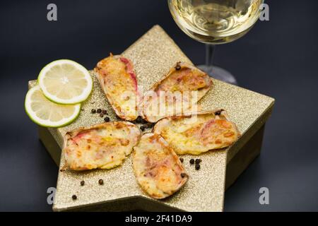 (machas a la parmesana) seashell cuit au parmesan. servi sur une étoile dorée Banque D'Images