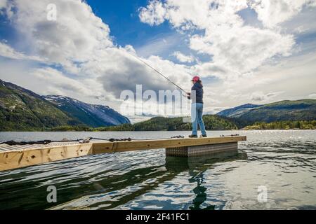 Femme pêchant sur la machine de pêche tournant en Norvège. La pêche en Norvège est un moyen d'adopter le mode de vie local. D'innombrables lacs et rivières, ainsi qu'un large littoral, offrent des opportunités exceptionnelles... Banque D'Images