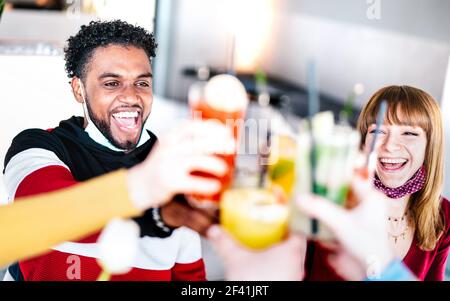 De jeunes amis qui boivent au bar à cocktails portant un masque ouvert - Nouveau concept d'amitié normale avec le couple ayant plaisir ensemble toaster les boissons Banque D'Images