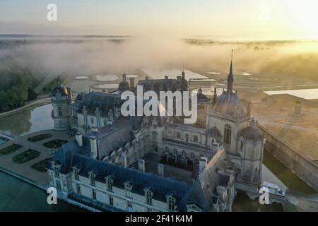 Vue aérienne de drone sur le château de Chantilly, Oise, France. Vue du matin sur le bâtiment historique dans un paysage brumeux. Atmosphère mystérieuse. Banque D'Images