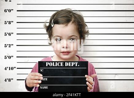 Petite fille posant avec un conseil des prisons Banque D'Images