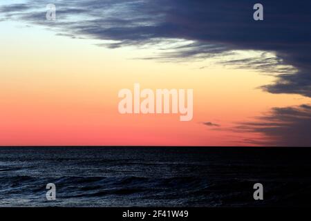 Un front de tempête s'approchant avec la lueur orange du lever du soleil fournissant une réunion conceptuelle du bien contre le mal. Banque D'Images