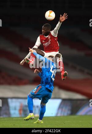 Oleg Reabciuk d'Olympiacos (à gauche) et Nicolas Pepe d'Arsenal se battent pour le ballon lors de la manche de la Ligue Europa de l'UEFA lors du match de la manche de seize secondes au stade Emirates, à Londres. Date de la photo: Jeudi 18 mars 2021. Banque D'Images