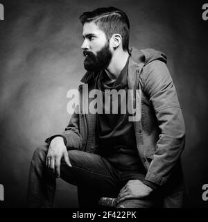 Portrait d'un homme de la main avec barbe et moustache. Image rapprochée d'un homme barbu brutal et sérieux sur fond sombre. Photographie noir et blanc Banque D'Images