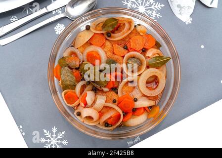 Filet de cabillaud frit dans une marinade à l'huile avec oignon, carotte et feuille de Laurier sur la table de vacances, isolé sur un fond blanc avec un chemin d'écrêtage, vue du dessus. Banque D'Images