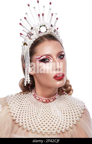 Belle femme dans un style créatif avec un maquillage lumineux et vêtements et accessoires blancs Banque D'Images