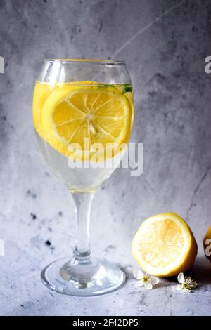 Citrons et un verre de limonade sur fond gris Banque D'Images