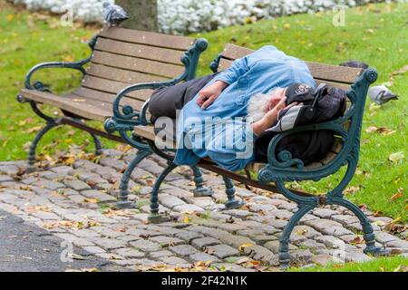 Saint John, Nouveau-Brunswick, Canada - 2017-10-10: L'homme est décédé sur un banc de parc. Banque D'Images