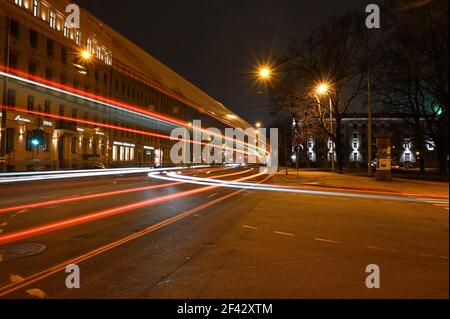 Coloré traversant des sentiers de lumière dans la ville la nuit qui va haut de la route que le bus passe. Banque D'Images