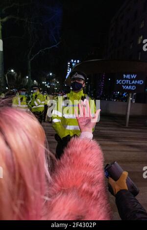 Londres, Royaume-Uni. 16 mars 2021. Une femme tient un tampon à un policier devant le New Scotland Yard. « il était juste à la maison » écrit dans sa main. Des milliers de personnes se sont rassemblées sur la place du Parlement pour sensibiliser la population à la sécurité des femmes et s’opposer au projet de loi du PCSC. La police du centre de Londres a procédé à des arrestations lundi soir alors que des milliers de personnes se sont rassemblées pour s'opposer à l'adoption d'un nouveau projet de loi sur les services de police et pour souligner la violence contre les femmes. Le projet de loi sur la police, la criminalité, la détermination de la peine et les tribunaux a été critiqué par des groupes de la société civile comme une atteinte à certains des droits les plus fondamentaux des citoyens. Manifestations autour Banque D'Images