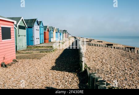 huttes colorées sur une plage de galets par une journée ensoleillée En Angleterre Banque D'Images