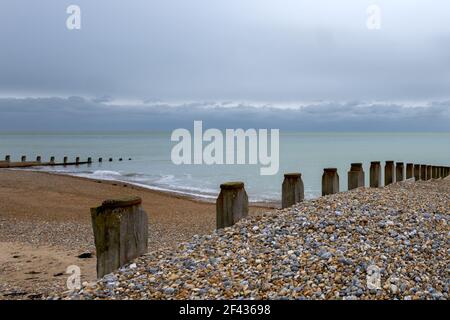 Groynes en bois sur la plage d'Eastbourne, à Sussex, en Angleterre, lors d'un après-midi hivernal nuageux Banque D'Images