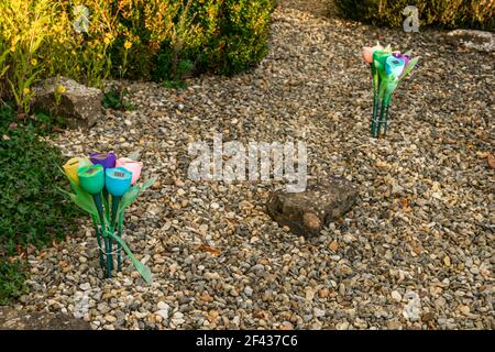 Lumières de fleurs à énergie solaire dans le jardin, deux ensembles de plastique illuminent des fleurs colorées comme une décoration de chemin de pierre de jardin Banque D'Images