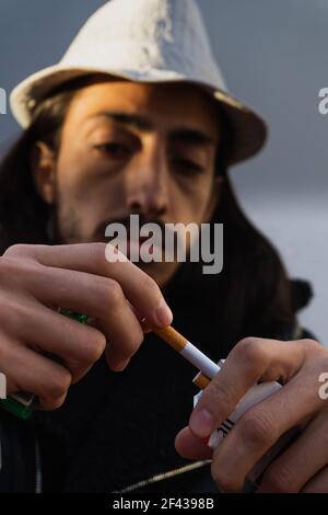 homme dans un chapeau à poil long tirant une cigarette d'un paquet de cigarettes. prêt à fumer le tabac. 31 mai Banque D'Images