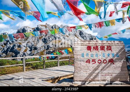 Signe et vue du sommet de la montagne de neige de Shika de 4500m de haut avec drapeaux de prière à Shangri-la Yunnan Chine (traduction : vallée de la lune bleue, neige de Shika m Banque D'Images