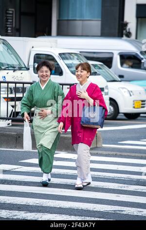 Deux femelles japonaises traversant le passage piéton zébré, Aoyama, Tokyo, Japon Banque D'Images