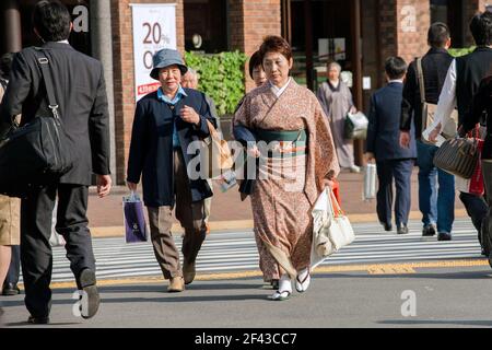 Femme japonaise d'âge moyen portant un kimono marchant dans le quartier commerçant de Ginza, Tokyo, Japon Banque D'Images