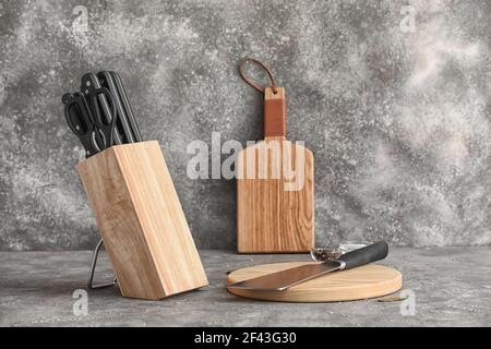 Jeu de couteaux sur support en bois sur fond de gringe Banque D'Images