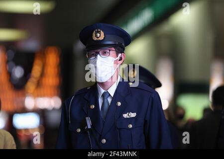 Tokyo, Japon. 18 mars 2021. Un policier japonais portant un masque facial comme mesure préventive contre la propagation de Covid-19 vu en service dans le district de Shibuya la nuit. Le gouvernement va lever l'état d'urgence dans la région de Tokyo le 21 mars 2021. Crédit : SOPA Images Limited/Alamy Live News Banque D'Images