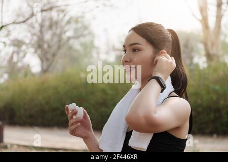 Bonne femme sportive dans un casque à l'extérieur dans le parc Banque D'Images