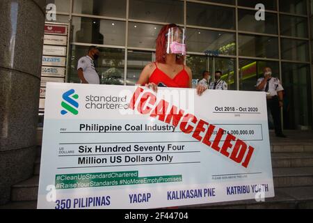 Makati City, Philippines. 19 mars 2021. Les activistes du climat ont tenu un énorme chèque annulé, alors qu'ils ont protesté devant la Standard Chartered Bank. Ils demandent à la banque de cesser de financer des projets d'énergie du charbon. Crédit : CIC de la majorité mondiale/Alamy Live News Banque D'Images