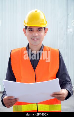 Ingénieur ou contremaître asiatique portant un gilet de sécurité et un casque de sécurité Banque D'Images