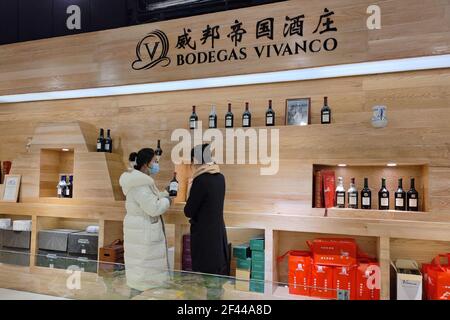 Pékin, province chinoise de Zhejiang. 18 mars 2021. Un vendeur présente le vin espagnol à un consommateur au marché international de Yiwu à Yiwu, dans la province de Zhejiang, en Chine orientale, le 18 mars 2021. Credit: Lin Guangyao/Xinhua/Alay Live News Banque D'Images