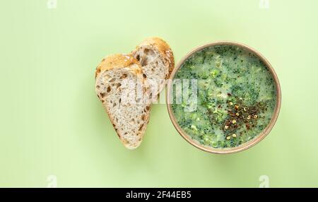 Concept de livraison de nourriture saine. La soupe à la crème de brocoli fraîche servi du pain frais et des épices dans un récipient artisanal. Banque D'Images