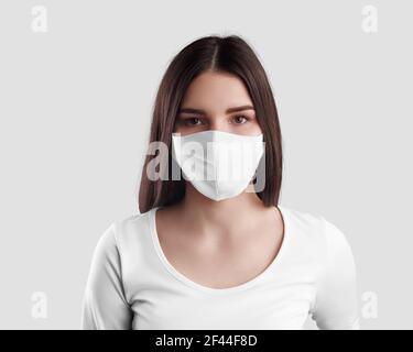 Maquette d'un masque blanc blanc sur une fille dans un chandail à cheveux foncés, protection du visage cousue, place pour la conception.gabarit de masque pour la protection contre v Banque D'Images