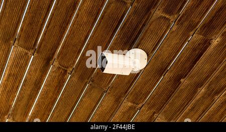 Un faible angle d'une caméra de sécurité installée sur un plafond en bois Banque D'Images