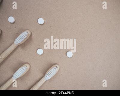 Brosse à dents en bambou et languettes dentaires sur un fond en bois comme un échange libre en plastique. Produits de soins personnels sans gaspillage. Banque D'Images