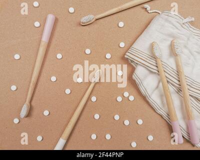 Brosse à dents en bambou et languettes dentaires sur un fond en bois comme un échange libre en plastique. Produits de soins personnels sans gaspillage. Banque D'Images