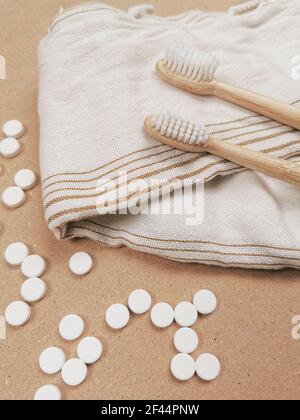 Brosse à dents en bambou et languettes dentaires sur un fond en bois comme un échange libre en plastique. Produits de soins personnels sans gaspillage. Banque D'Images