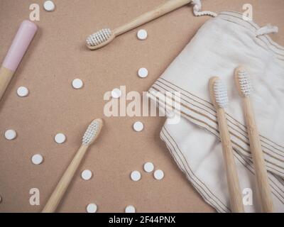 Brosse à dents en bambou et languettes dentaires sur un fond en bois comme un échange libre en plastique. Produits de soins personnels sans gaspillage. Banque D'Images