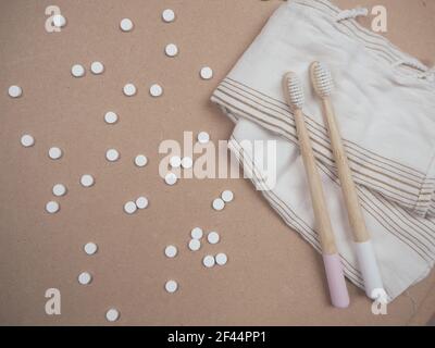 Brosse à dents en bambou et languettes dentaires sur un fond en bois comme un échange libre en plastique. Produits de soins personnels sans gaspillage. Banque D'Images