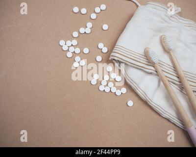 Brosse à dents en bambou et languettes dentaires sur un fond en bois comme un échange libre en plastique. Produits de soins personnels sans gaspillage. Banque D'Images
