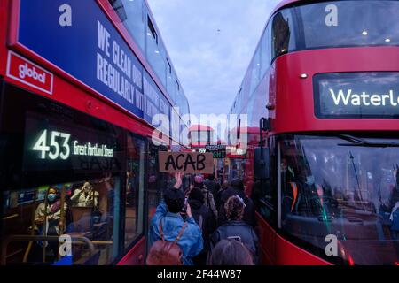 Londres, Royaume-Uni. 15 mars 2021. Une personne détient un panneau indiquant « ACAB » lors d'une marche entre les bus rouges de londres. Des milliers de personnes se sont rassemblées dans la Squ parlementaire Banque D'Images