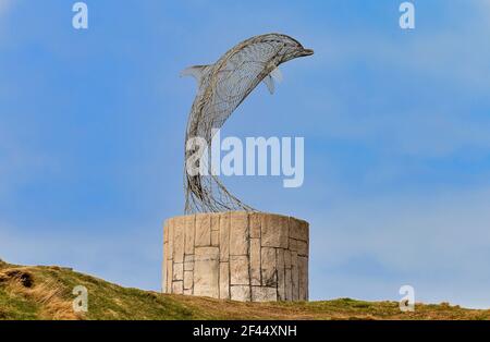 PORTSOY OLD HARBOUR MORAY FIRTH ABERDEENSHIRE SCOTLAND SCULPTURE DES DAUPHINS UNE PETITE COLLINE SURPLOMBANT LE PORT Banque D'Images