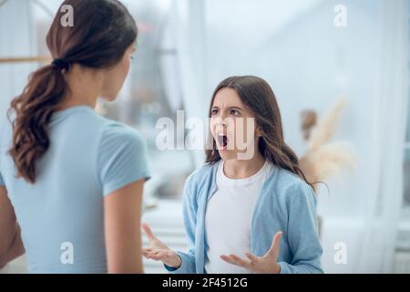 Colère hurlant jeune fille et écoutant maman Banque D'Images