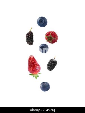 Les baies fraîches isolées flottent dans l'air. Fruits de mûrtille, de bleuet, de framboise et de fraise tombant isolés sur fond blanc avec chemin de coupure. Banque D'Images