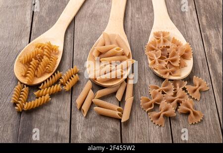 Assortiment de pâtes de blé entier sur une table en bois. Banque D'Images