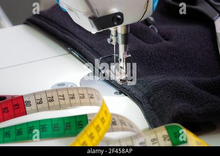 coudre une fermeture éclair dans un sweat-shirt en polaire Banque D'Images