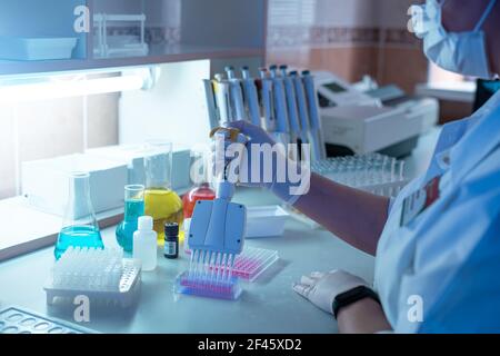 Femme scientifique travaillant en laboratoire et l'examen de biochimie l'échantillon en tube à essai. La recherche et le développement de la science concept de l'étude. Banque D'Images