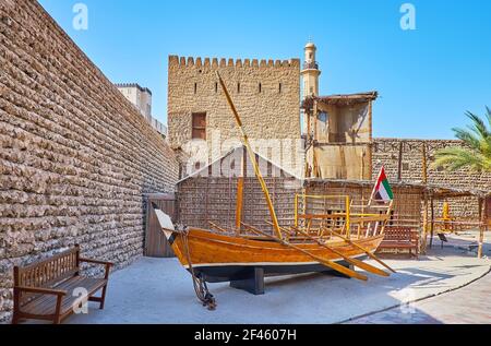 La cour du fort d'Al Fahidi avec un bateau de pêche de sambuk en bois d'époque et une maison d'été typique de palmier (arish), surmontée d'une tour de windcatcher, Dubaï, Banque D'Images