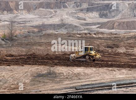 La lame a récupéré le paysage autour de la fosse ouverte. Processus de restauration des terres. Bulldozer lors de la remise en état de la mine une fois l'extraction du sable terminée. C Banque D'Images