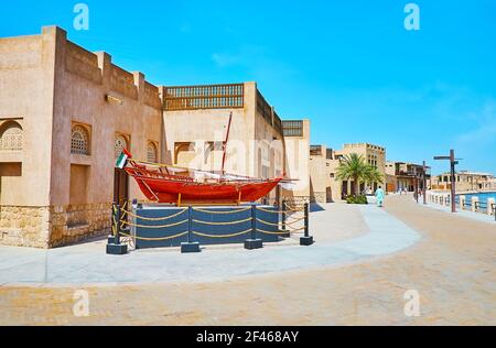 Le stand avec bateau de pêche traditionnel en bois sambuk sur le remblai de Dubai Creek à la maison adobe du quartier Al Shindagha, Dubaï, Émirats Arabes Unis Banque D'Images