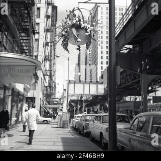 1960s, historique, de jour et du centre-ville de Chicago, États-Unis, Wabash Avenue, montrant une section de la ligne de chemin de fer surterrestre ou surélevée, le Chicago 'l', le système de transport rapide desservant la ville, exploité par la Chicago Transit Authority (CTA). Voitures garées dans la rue, la taverne House sur la gauche et la tour Millers sur la droite. Banque D'Images