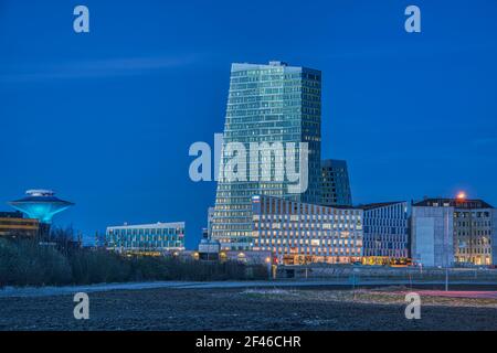 Vue de nuit sur le quartier financier et d'affaires de Hyllie, connu pour son architecture moderne, avec un gratte-ciel se tenant à l'extérieur des bâtiments Banque D'Images