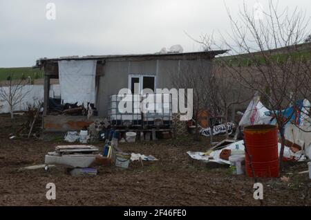 Le jardin d'une maison sale et désordonnée pleine de choses. La maison des squatters. Banque D'Images